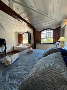 a bedroom with two beds with towels on them at Origem Buziana in Búzios +150 photos