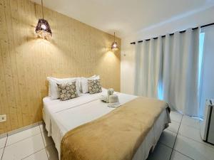 a bedroom with a large white bed with two pillows at Pousada Arte do Velejo by Solarium in São Miguel do Gostoso