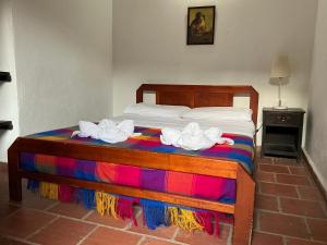 a bed with two towels on top of it at Luna Munay Hostel in Curití
