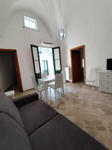 a living room with a couch and a table and chairs at La NICCHIA in Monteroni di Lecce