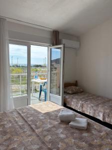 a bedroom with two beds and a balcony at Villa Cherry in Bar