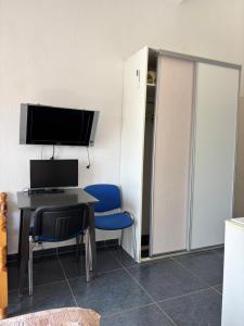 a room with a desk with a computer and two blue chairs at Villa Cherry in Bar