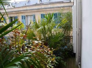 une porte ouverte menant à un jardin avec des plantes dans l'établissement Luxembourg Apartment, à Paris
