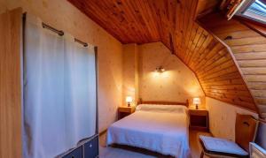 a bedroom with a bed and a wooden ceiling at Gîte de Malavals in Castelnau-de-Mandailles
