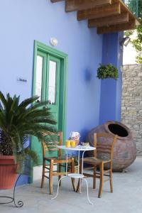 a table and chairs in front of a blue wall at To Konatzi tis Marikas tzai tou Yianni in Kato Drys