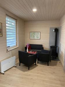 a living room with a couch and chairs and a stove at Motel Level 2 in Miastko