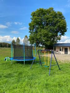 two playground equipment in a field with a tree at Motel Level 2 in Miastko