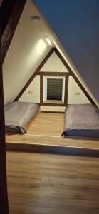 a room with two beds in a roof with a window at Ferienwohnung Menz Liliensteinblick in Pfaffendorf