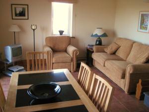 uma sala de estar com um sofá e uma mesa em 30 Dun an Oir em Ballyferriter