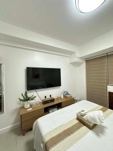 a bedroom with a large bed and a flat screen tv at The Waltham Place in Lagundi