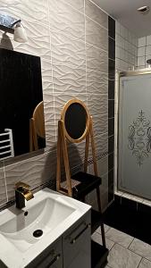 a bathroom with a sink and a chair next to a mirror at La loge secrète Love Room in Dolus-le-Sec