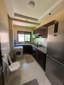 a kitchen with a refrigerator and a washer and dryer at Dar AMIRA in Ben Yakhlef