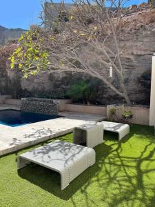 a garden with two white beds and a tree at Increible Casa con vista al mar in La Paz +6 photos