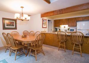 a kitchen and dining room with a wooden table and chairs at 10 Quelah Condo in Sunriver