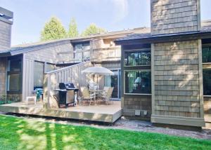 a patio with a table and an umbrella at 10 Quelah Condo in Sunriver +12 photos