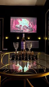 a glass table with a bottle of wine and two glasses at La loge secrète Love Room in Dolus-le-Sec