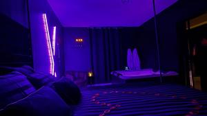 a purple room with a bed and a chair at La loge secrète Love Room in Dolus-le-Sec