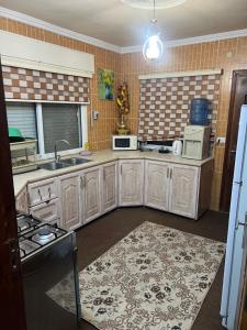 a large kitchen with wooden cabinets and appliances at اربد الحي الشرقي in Irbid +10 photos