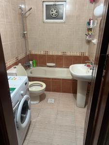 a bathroom with a toilet sink and a washing machine at اربد الحي الشرقي in Irbid