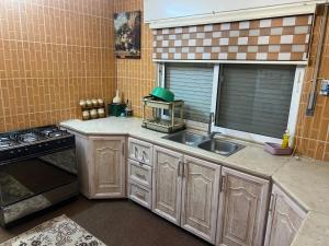 a kitchen with a sink and a stove and a window at اربد الحي الشرقي in Irbid