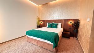 a bedroom with a large bed with green pillows at MY HOTEL in Prizren +50 photos
