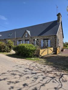 a stone house with a black roof and a driveway at Gîte la belle etoile proche de Granville in Ver