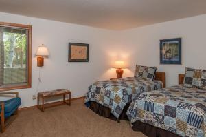 a hotel room with two beds and a window at 108 Quelah Condo in Sunriver +15 photos