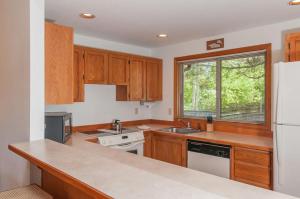 a kitchen with wooden cabinets and a white refrigerator at 108 Quelah Condo in Sunriver