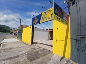 a yellow building with signs on the side of it at Pousada Imperatriz in Aparecida