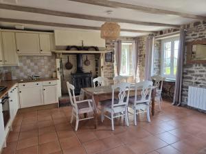 a kitchen with a table and chairs in a room at Gîte la belle etoile proche de Granville in Ver +31 photos