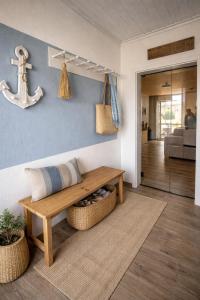 a living room with a wooden bench and a wall at Ferienhaus Deichkrone in Dornum +29 photos