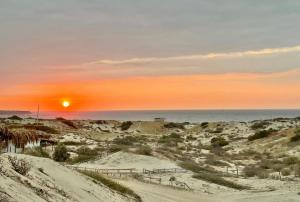 a sunset over the beach with the ocean in the background at Villa Vichayo Bungalows in San Martín
