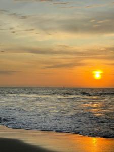 a sunset on the beach with the ocean at Villa Vichayo Bungalows in San Martín +1 photo