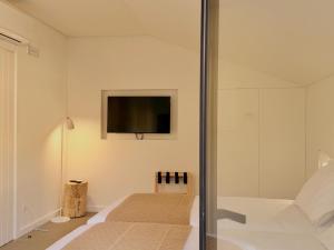 a bedroom with a bed and a tv on the wall at Grota Lodging in Leiria