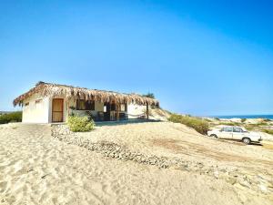 a house on the beach with a car parked next to it at Villa Vichayo Bungalows in San Martín