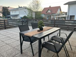 a table and chairs with a potted plant on a patio at Apartma Prospera - free parking in Maribor