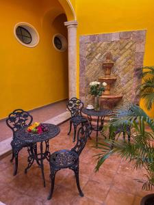 eine Terrasse mit zwei Tischen und Stühlen sowie einem Brunnen in der Unterkunft Maya Campeche Hotel in Campeche