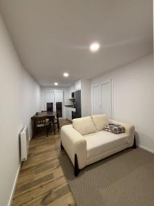 a living room with a white couch and a table at Coração d`Alice in Monção