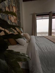 a bedroom with a white bed and a window at Casa Amanecer in Tonosí
