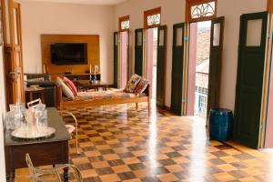 a living room with a couch and a tv at Casa Antunes in Diamantina