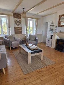a living room with a coffee table and a fireplace at Gîte la belle etoile proche de Granville in Ver