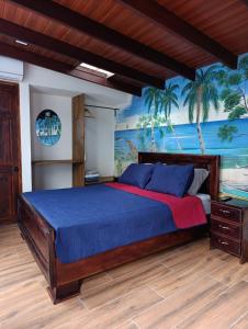 a bedroom with a bed with blue sheets and palm trees at Villas Kiki in Puerto Viejo +170 photos