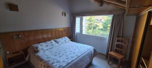 a small bedroom with a bed and a window at Laderas Verdes in Esquel +37 photos