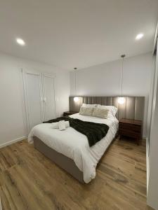 a bedroom with a large bed and a wooden floor at Coração d`Alice in Monção