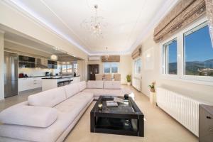 a living room with a white couch and a table at Gerasimos Dream House - 7 Minutes from the Airport in Lakíthra
