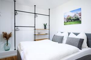 a bedroom with a white bed with a black and white headboard at Appartement im Weiherhaus in Forchheim