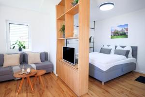 a small room with a bed and a couch at Appartement im Weiherhaus in Forchheim