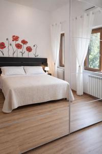 a bedroom with a bed with red flowers on the wall at Casa Annalisa in Scauri