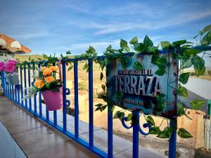 a fence with potted plants and a sign on it at Alojamiento Rural La Tinaja in Ayna