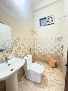 a bathroom with a white toilet and a sink at HOTEL O DEV RAJ Homestay in Rishīkesh